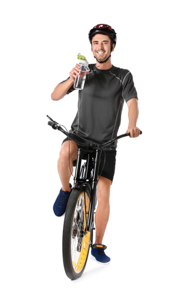 Männlicher Radfahrer trinkt Wasser auf weißem Hintergrund - Foto, Bild