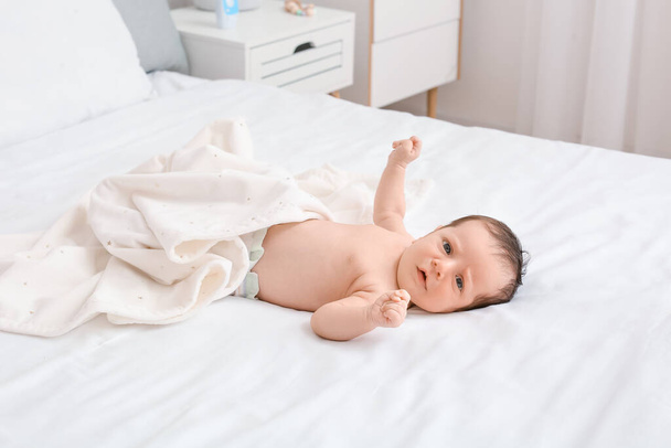 Niedliches kleines Baby liegt zu Hause im Bett - Foto, Bild