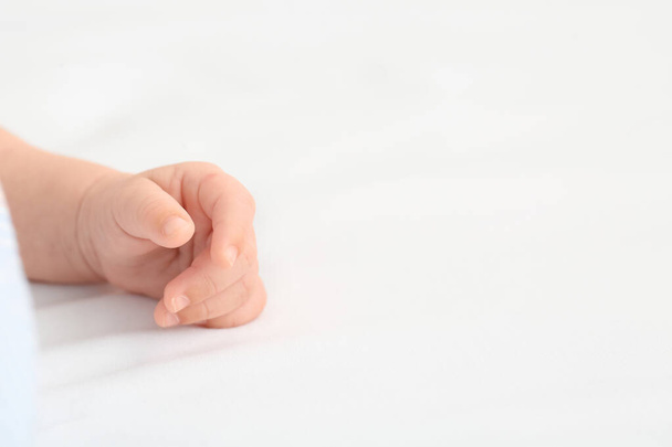 Yatakta uzanmış küçük şirin bir bebek eli - Fotoğraf, Görsel