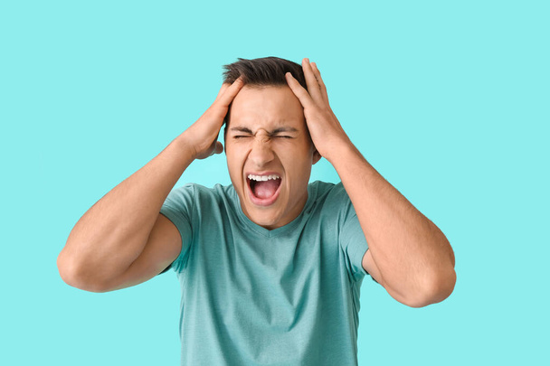 Stressed young man on color background - Photo, Image