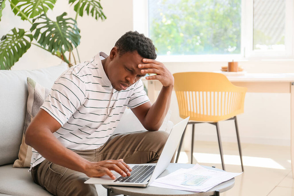 Стресс афроамериканец с ноутбуком дома - Фото, изображение