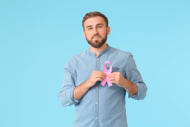 Człowiek z różową wstążką na tle koloru. Koncepcja świadomości raka piersi - Zdjęcie, obraz