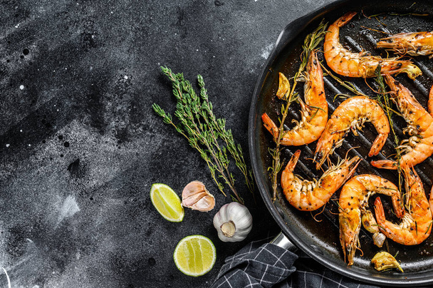 Shrimp, prawn Scampi traditional dish fried in garlic batter with lemon and parsley. Healthy food. Black background. Top view. Copy space. - 写真・画像