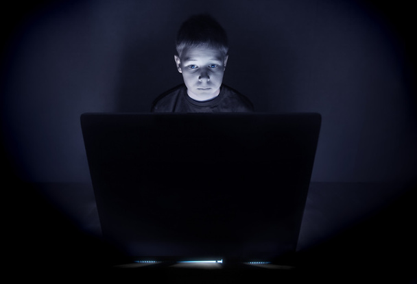 Boy illuminated by the blue light of a computer monitor - Photo, Image