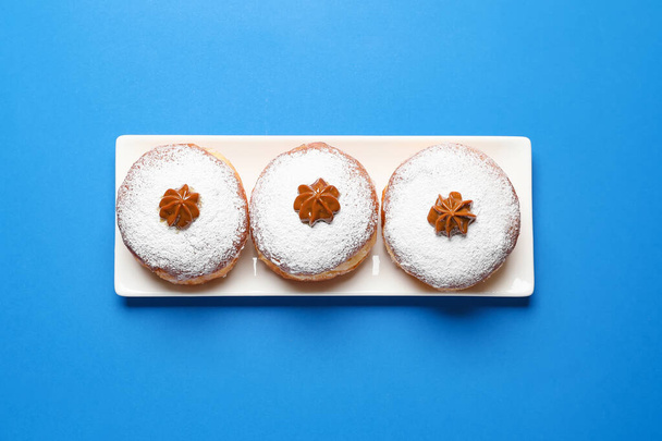 Leckere Donuts für Chanukka auf farbigem Hintergrund - Foto, Bild
