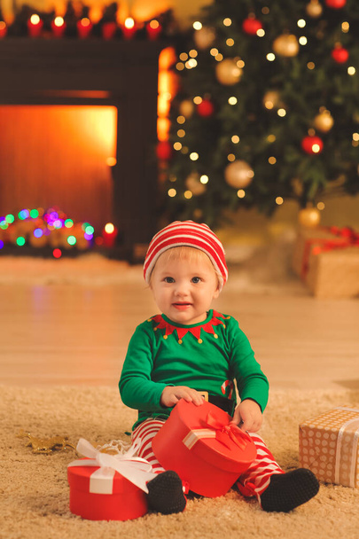Schattig klein baby in elf kostuum thuis op kerstavond - Foto, afbeelding