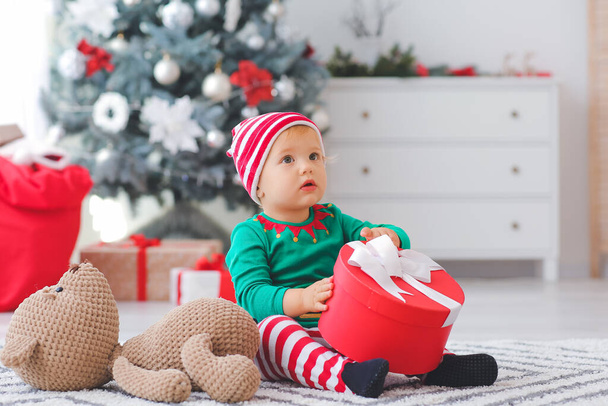Słodkie małe dziecko w kostiumie elfa w domu w Wigilię - Zdjęcie, obraz