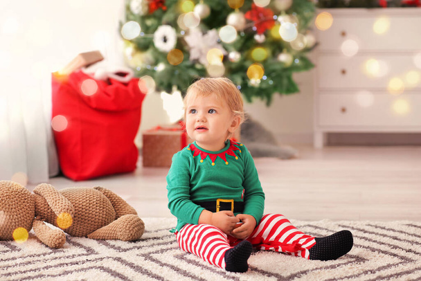 Cute little baby in elf's costume at home on Christmas eve - Photo, Image