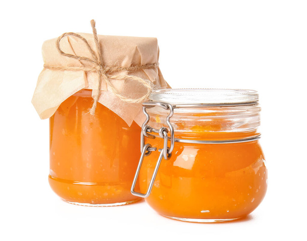 Jars of tasty pumpkin jam on white background - Фото, изображение
