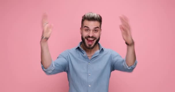junger sexy lässiger Mann im Rückspiegel dreht sich um, ist aufgeregt, schreit und feiert Erfolge auf rosa Hintergrund - Filmmaterial, Video