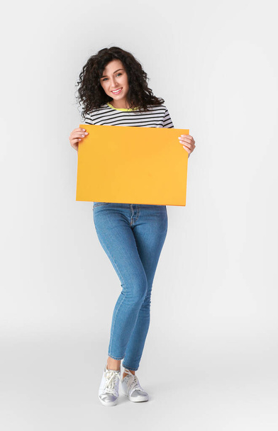 Woman with blank paper sheet on light background - Foto, Imagen