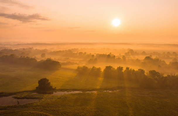 Doğanın manzarası. Ülkenin üzerinde yükselen güneş sisle kaplı.. - Fotoğraf, Görsel