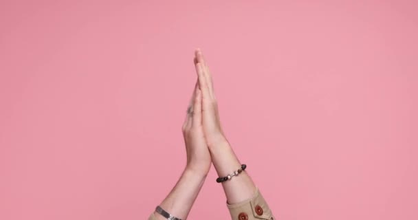 zwei Hände klatschen, zeigen auf die Kamera und zeigen mit dem Daumen nach oben auf rosa Hintergrund - Filmmaterial, Video