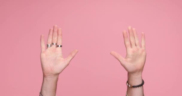 two hands gesturing hey you, give me five and you suck on pink background - 映像、動画
