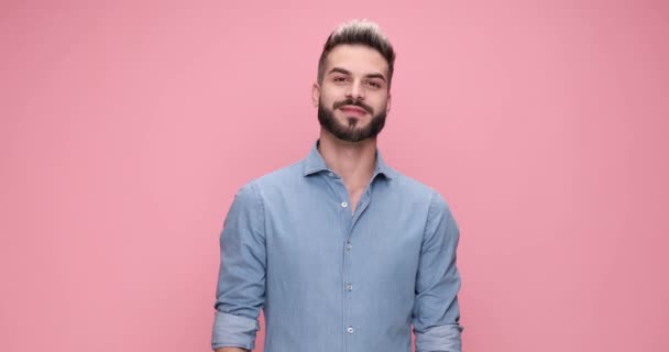 casual smiling man clapping his hands, pointing at the camera and feeling excited on pink background - Metraje, vídeo