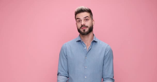 knap verrast casual man wijzend vinger en het verhogen van zijn vuist vol enthousiasme tegen roze achtergrond - Video