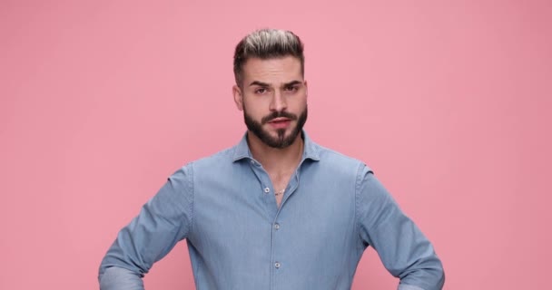 casual man can not believe what he sees, slapping his head and making worries on pink background - Metraje, vídeo