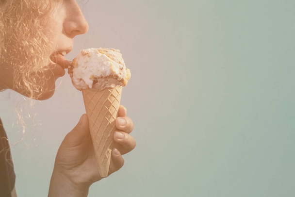 Chica comer conos de helado sobre fondo azul - Foto, Imagen