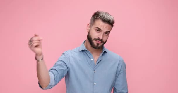 knappe casual man probeert te horen waht iemand zegt op roze achtergrond - Video