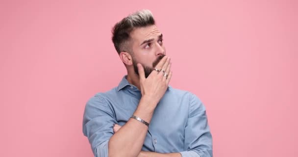 sexy casual man covering his mouth, feeling tired then suddenly feeling fresh on pink background - Video, Çekim