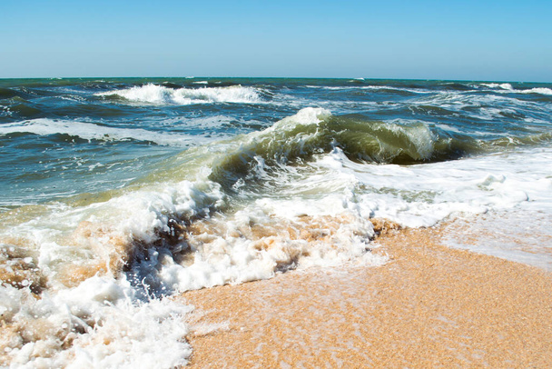 Κύματα σε μια παραλία της θάλασσας μια ηλιόλουστη μέρα - Φωτογραφία, εικόνα
