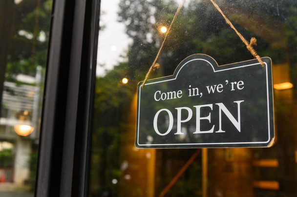 COME IN, WE ARE OPEN - Відкритий знак широко висить на вхідних дверях з копією простору в кав'ярні або ресторані
 - Фото, зображення