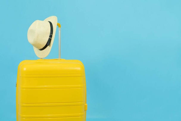 Summer time - Yellow suitcase or luggage with hat and sunglasses on pastel blue background minimal creative travel concept Holiday Adventure Trip. - Fotografie, Obrázek