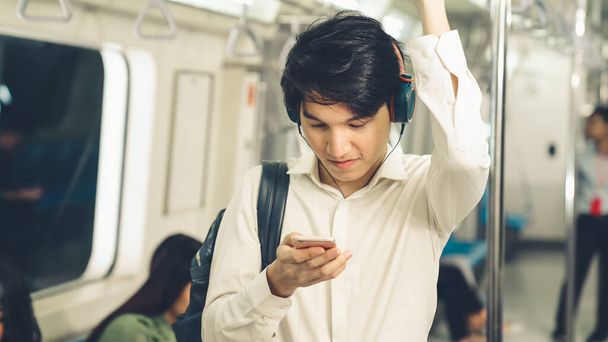 Biznesmen korzystający z telefonu komórkowego w pociągu publicznym - Zdjęcie, obraz