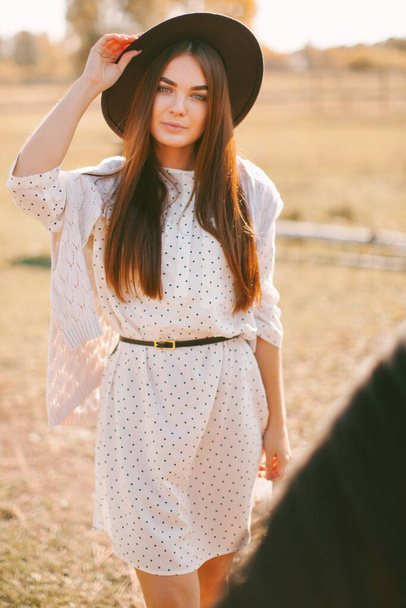 Young beautiful model in a hat on a farm - Fotó, kép