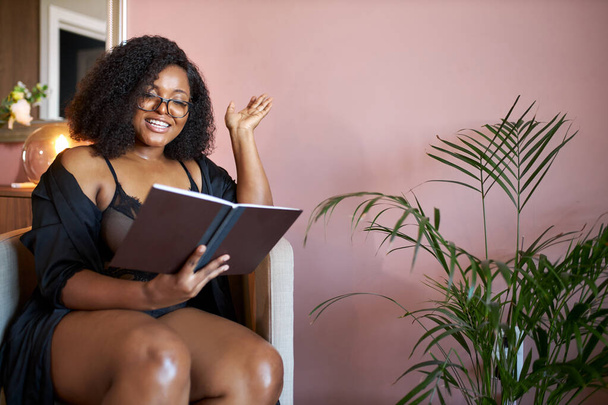 nadwaga czarny kobieta czytać książkę w domu - Zdjęcie, obraz