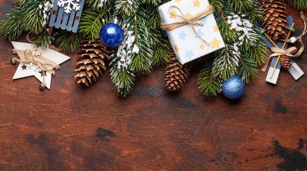 Kerstkaart met dennenboom en decoratie op houten achtergrond en kopieer ruimte voor uw kerstgroeten. Bovenaanzicht vlak lay - Foto, afbeelding