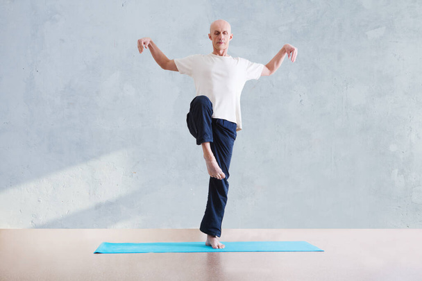 man praticing tai chi chuan in the gym. Chinese management skill Qi's energy. WU-SHU. Man practicing yoga. - Fotoğraf, Görsel