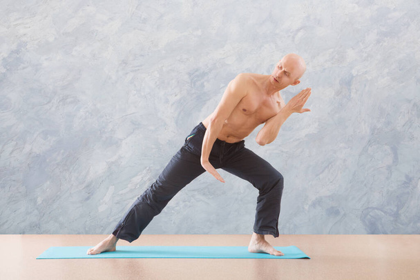 man praticing tai chi chuan in the gym. Chinese management skill Qi's energy. WU-SHU. Man practicing yoga. - Fotó, kép