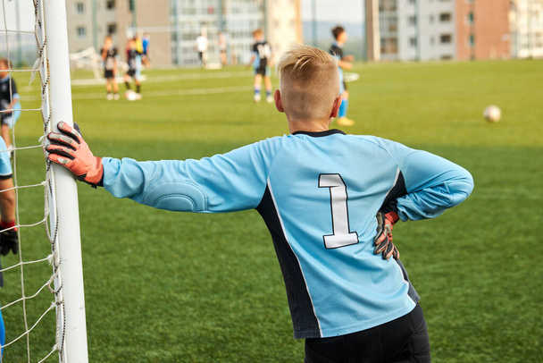 rear view on young kid boy goalkeeper - 写真・画像