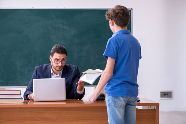 Young male teacher and schoolboy in the classroom - Photo, Image