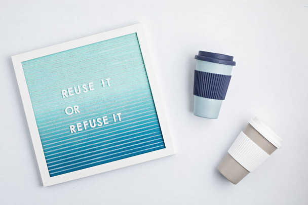 Reusable coffee cup and letterboard with text reuse it or refuse it. Zero waste sustainable lifestyle. Eco friendly habbits for take away coffee - Fotografie, Obrázek