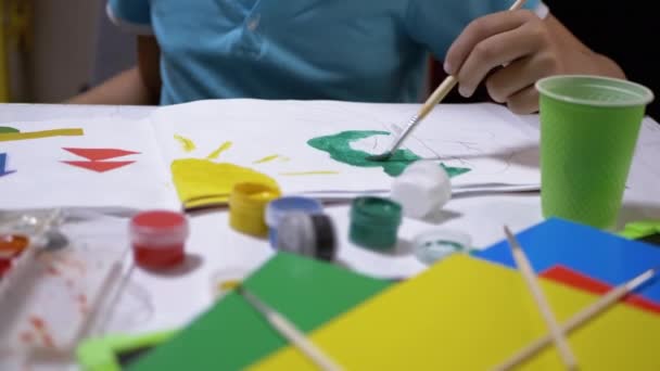 Child with a Brush in Hand Paints Tree with Green Paint on White Sheet of Paper - Footage, Video