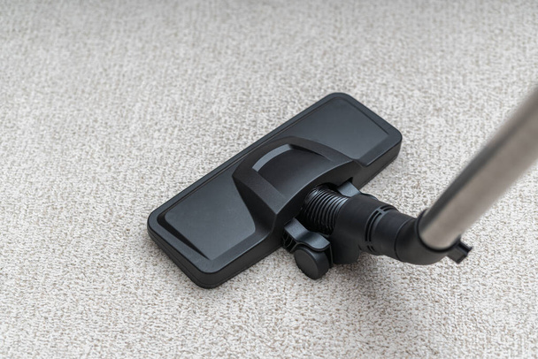Vacuum cleaner is cleaning dust from carpet. Housework cocnept. - Photo, Image
