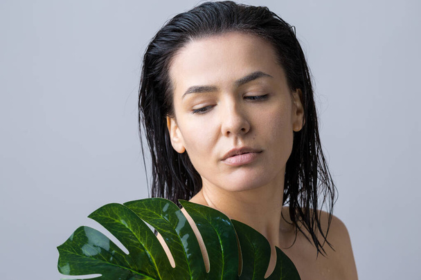 Schönheit Frau mit natürlichem grünen Palmblatt-Porträt. Mode, Schönheit, Make-up, Kosmetik. - Foto, Bild