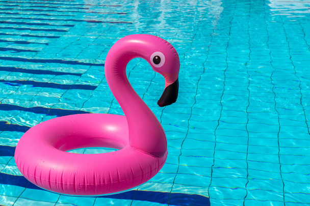 Letní zábava. Růžové nafukovací plameňák v bazénu vody pro letní pláž pozadí. Luxusní životní styl cestování - Fotografie, Obrázek