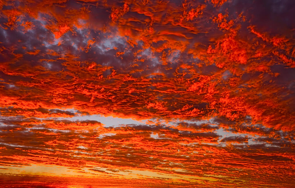Impresionantes nubes rojas de fuego al atardecer en el tropical norte de Queensland, Australia durante la temporada de monzones con colores vivos de rojos y naranja perfecto para el fondo. - Foto, Imagen