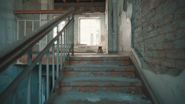 Знищена школа в Беслані після теракту. Старі пусті шкільні коридори. Камера піднімається сходами.. - Фото, зображення