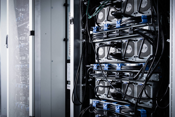 A row of racks with data storage hardware inside server room - Foto, afbeelding
