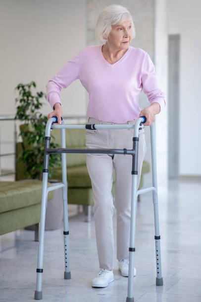 Elderly woman with a rolling-walker looking serious - Photo, image