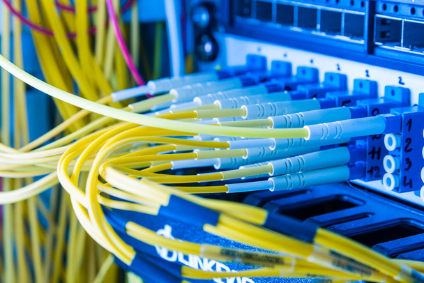 fiber optic cables plugged in network switch panel inside data center - Photo, Image
