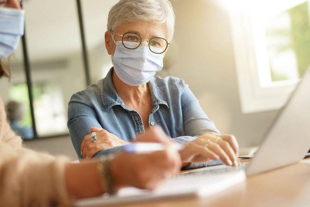 Business women working in office with face mask during 2019-ncov pandemia - Foto, afbeelding