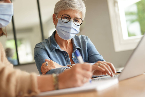 Business women working in office with face mask - Photo, image