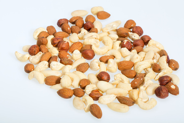 frutos secos mezclados avellanas, nueces, anacardos, piñones aislados sobre fondo blanco
 - Foto, imagen