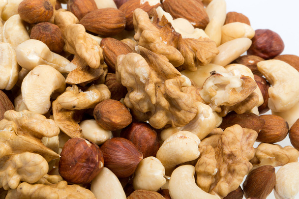 achtergrond van gemengde noten - hazelnoten, walnoten, cashewnoten en pijnboompitten - Foto, afbeelding