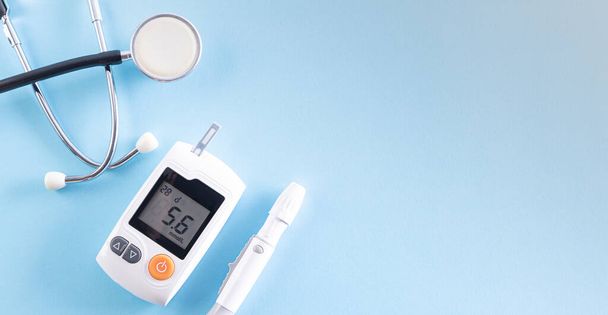 Horní pohled na diabetes tester set se stetoskopem na jasně modrém pastelovém pozadí. Zdravá péče a lékařská koncepce. - Fotografie, Obrázek